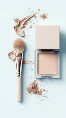 A makeup brush and a compact of powder are shown on a light blue background with scattered powder.