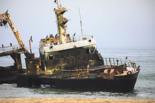 Zeila shipwreck, a haunting skeletal frame embraced by the turbulent Atlantic along the Skeleton Coast near Henties Bay. Zeila was an offshore fishing vessel that ran aground in 2008. Namibia