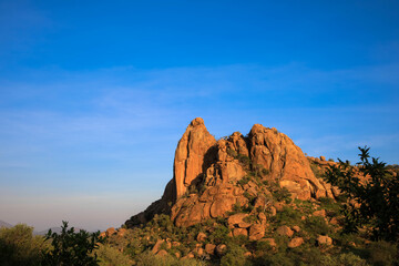 Scattered brown sandstone and rugged rock formations against a blue sky. Photographed in the Waterberg region. Panoramic view of the sandstone cliffs of the Waterberg. Namibia, Africa.