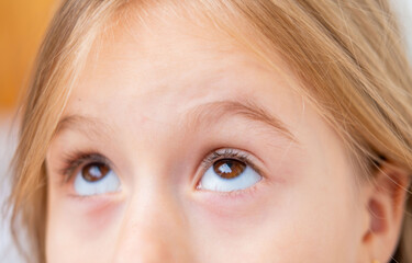 child, young girl's eyes looks intently something above, apprehension or lack certainty, ophthalmological examination, suspicion and distrust, suspicious or perplexed, Childhood fear and anxiety