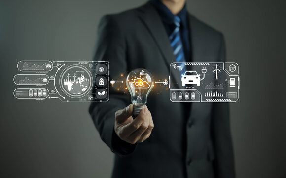 Businessman holding light bulb with eco innovation icons and smart technology interface for renewable energy, green business, and sustainable development concepts.