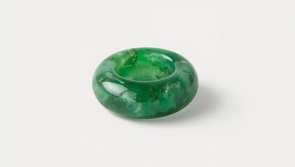 Jadeite green mineral ring carved smoothly on plain white background