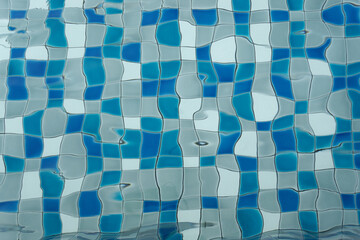 Ripples on the water surface and blue tile texture of swimming pool background