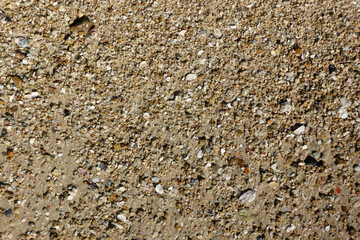 Pebbles on the beach, sand texture background