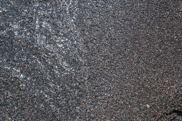 Black volcanic sand at Perissa Beach, Santorini, Cyclades, Greece