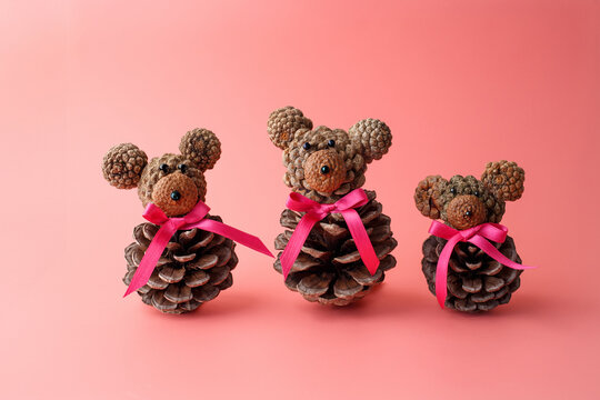 Three pinecone bears with acorn heads and pink ribbons, perfect for Christmas DIY tutorials, nature-themed crafts, educational materials, children workshops, seasonal branding