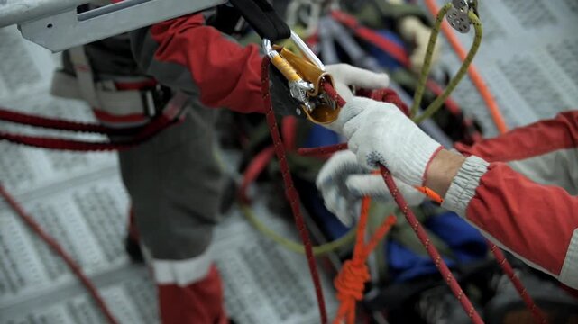 Rope access training with workers adjusting safety system