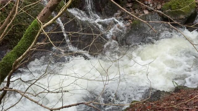 Water rushing down a river in slow motion in Wales in winter rainfall. Nature in the winter England UK 4K