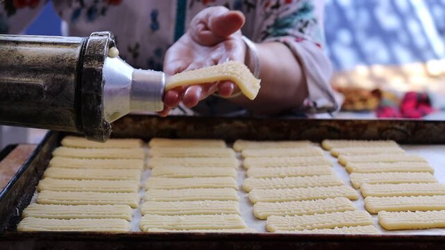 4K Slow Motion: Woman Making Halwa Lbouq (Moroccan Horn Pastry) - Batch of Sesame-Coated Pastries Ready to Bake, Shaping Raw Dough with Traditional Cookie Press for Eid/Ramadan Home Baking