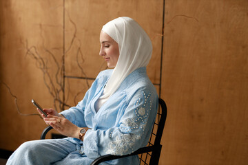 Muslim woman in a hijab with a mobile phone	
