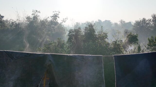 Sunlight drying clothes as warm solar heat evaporates water from fabric, showcasing natural laundry drying, bright outdoor sunlight, rising steam and fresh, eco-friendly household drying process