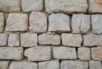 High-resolution close-up of a stacked stone wall showing rough, natural textures, irregular shapes, and earthy tones—ideal for backgrounds, architectural design, construction materials, and texture