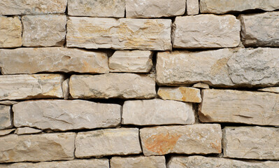 High-resolution close-up of a stacked stone wall showing rough, natural textures, irregular shapes, and earthy tones—ideal for backgrounds, architectural design, construction materials, and texture