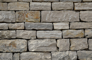 High-resolution close-up of a stacked stone wall showing rough, natural textures, irregular shapes, and earthy tones—ideal for backgrounds, architectural design, construction materials, and texture