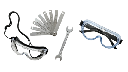 Assortment of Automotive Tools Including Spark Plug Gap Tool Wrench and Safety Goggles on a Black Background Isolated Studio Shot