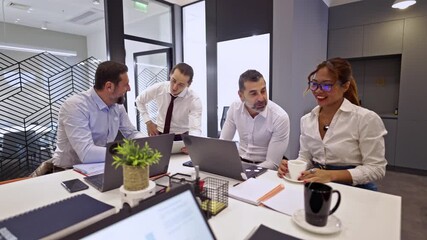 Professional business colleagues engaged in a lively discussion around a table in a bright, modern office. Their collaborative teamwork and communication drive innovation and success. - Powered by Adobe