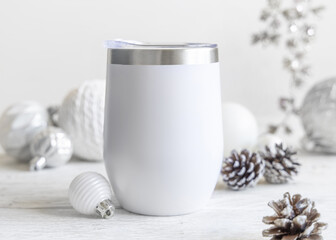 White blank Stainless Steel wine tumbler near Christmas baubles and decor on table, mockup