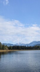 Rainbow Park, Whistler, British Columbia, Canada: the trail and park along Rainbow Lake on a good weather day with blue sky and reflection of trees