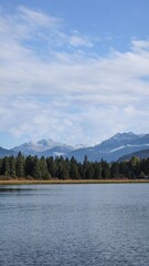 Rainbow Park, Whistler, British Columbia, Canada: the trail and park along Rainbow Lake on a good weather day with blue sky and reflection of trees