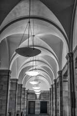 Arched Hallway with Ceiling Lamps in Black and White.