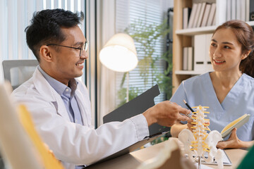 Doctor teaching medical team during a clinical session. Healthcare professionals learn together, discussing anatomy models and patient cases to enhance medical knowledge and treatment skills.