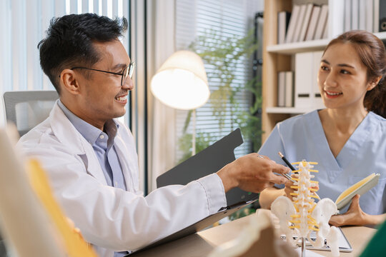 Doctor teaching medical team during a clinical session. Healthcare professionals learn together, discussing anatomy models and patient cases to enhance medical knowledge and treatment skills.