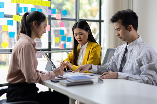 Collaborative team planning in office. Diverse team engaged in a business meeting, discussing strategies and analyzing documents.