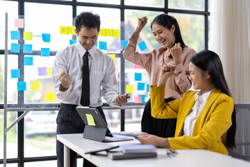 Diverse team of professionals celebrates a successful project in office.