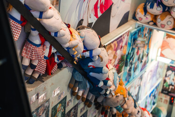 A narrow Tokyo anime shop staircase is lined with plush doll characters and walls of manga and idol...
