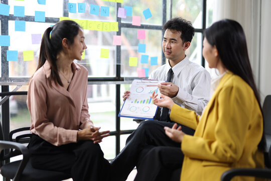 Team Collaborating on Business Strategy in Modern Office. Diverse team collaborating on business strategy, analyzing charts and graphs in office.