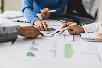 Business people analyzing financial charts and graphs at meeting.