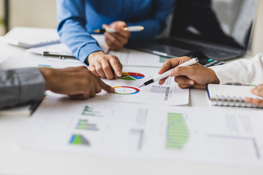 Business people analyzing financial charts and graphs at meeting. - Powered by Adobe