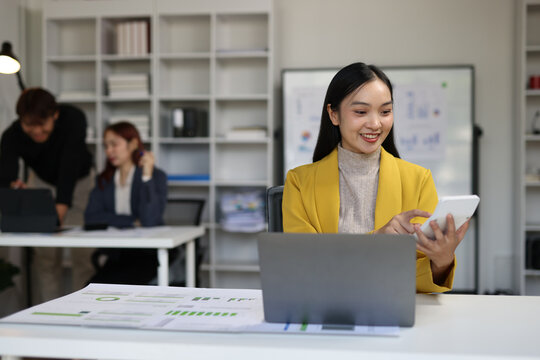 Asian businesswoman working with laptop and analyzing financial data in office.