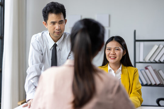 Business Team Engaging in Productive Meeting. Diverse group of professionals collaborating in a modern office setting. Smiling woman surrounded by colleagues taking notes and brainstorming.