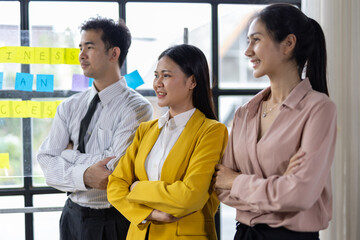 Diverse group of professionals stands confidently in an office.