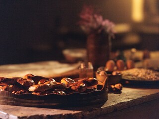 Delicious Romanian mucenici lie on a wooden platter, surrounded by traditional ingredients and warm light, evoking the spirit of a festive culinary celebration