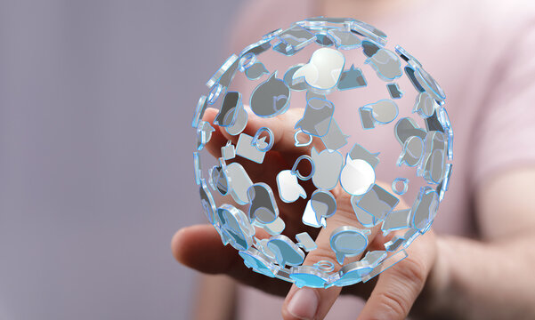 Abstract image of a person's hand holding a globe made of communication symbols representing global connection and technology.