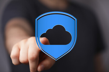 Hand pressing a cloud data protection button, representing digital security, safety, and cloud computing concep