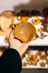 Woman holding a handmade ceramic shell used as jewelry holder or decor.
