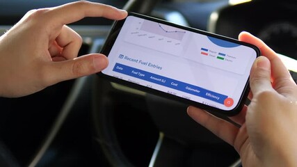 A driver uses his smartphone to study detailed analytics of his fuel consumption patterns. This clip captures the modern approach to car ownership, where data is used to optimize costs and understand - Powered by Adobe