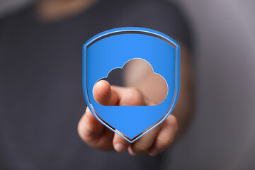 A hand pointing towards a digital cloud shield, symbolizing data protection and secure online storage for busin