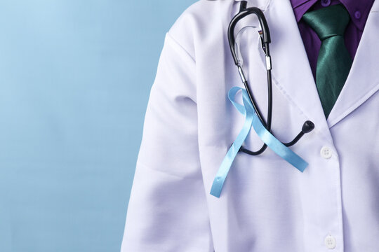A doctor is wearing a prostate cancer ribbon on an isolated background