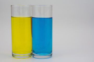 The photo shows two glasses with different colored drinks.
