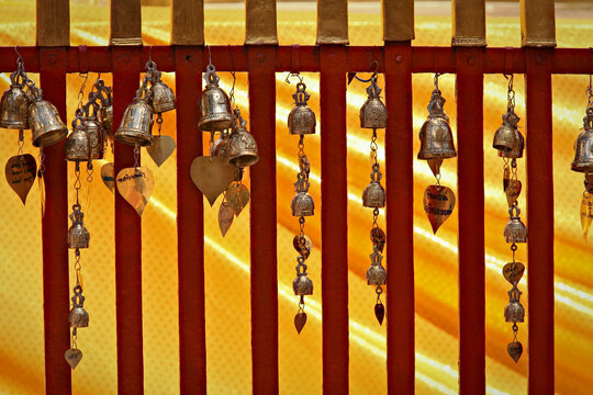 Small metal bells hanging from a railing in an ancient temple, Chang Mai