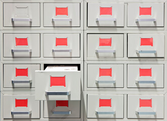 Drawers and red labels in an antique archive cabinet with index cards in a public library