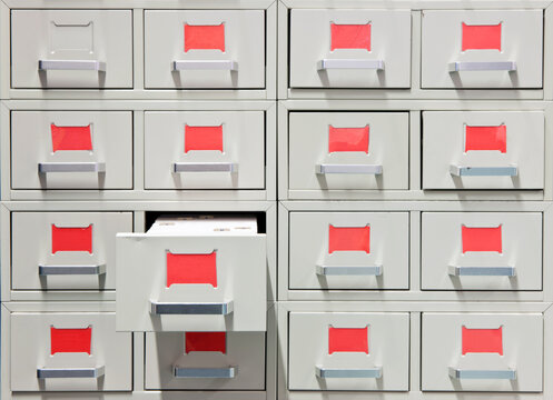 Drawers and red labels in an antique archive cabinet with index cards in a public library