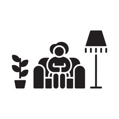 Person relaxing in armchair with plant and floor lamp