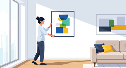Obraz premium A woman adjusts a framed artwork in a sunlit living room with a sofa and another artwork on the wall