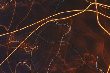 Abstract streaks of warm golden light blur across a dark textured background creating a sense of movement and energy