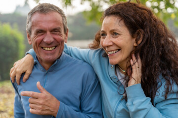 Obraz premium Senior couple hugging, laughing and smiling, enjoying healthy active lifestyle outdoors